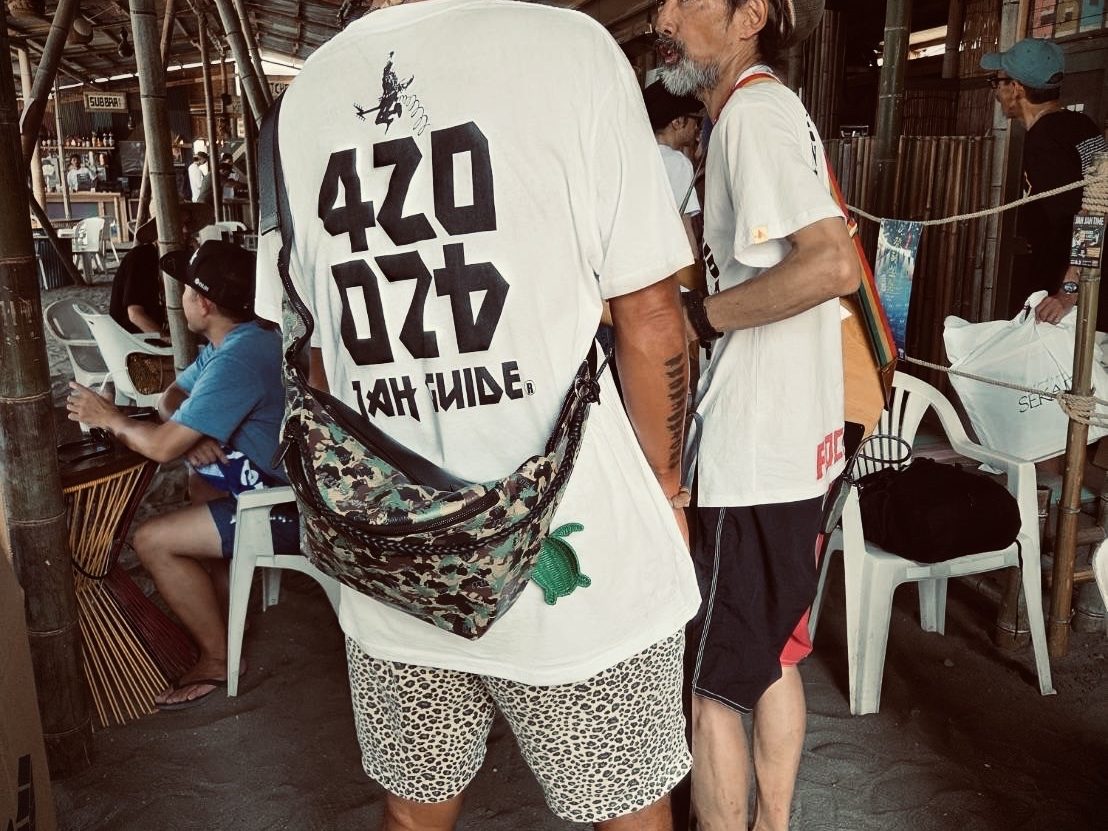 バンコクの海辺の小屋。Tシャツの背に入ったJAH GUIDEのロゴ